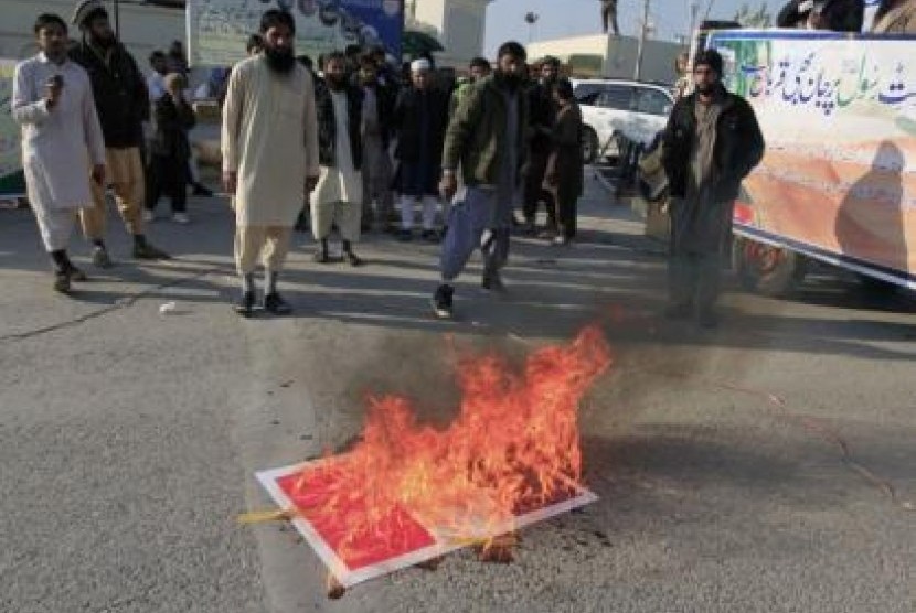 Replika bendera Prancis dibakar oleh pengunjuk rasa yang mengutuk penerbitan kartun Nabi Muhammad oleh Charlie Hebdo di Islamabad.