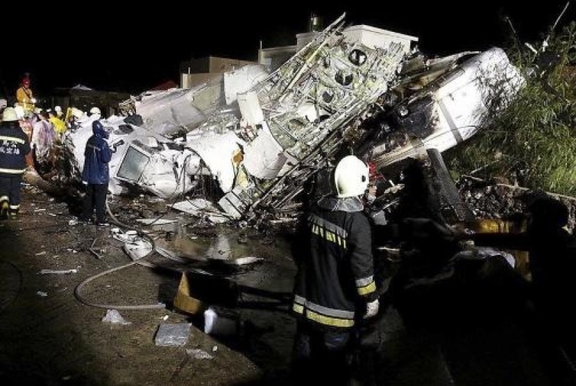 Rescue personnel survey the wreckage of TransAsia Airways flight GE222 on Taiwan's offshore island of Penghu, July 23, 2014.