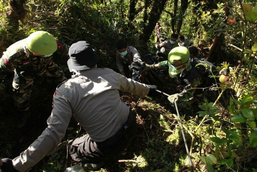 Rescue team members carry the dead body of a passenger from the Sukhoi Superjet crash from a valley at the peak of Mount Salak, near Sukabumi, Sunday. Salvage teams have descended into a ravine to search for the flight recorders from the Russian Sukhoi Sup