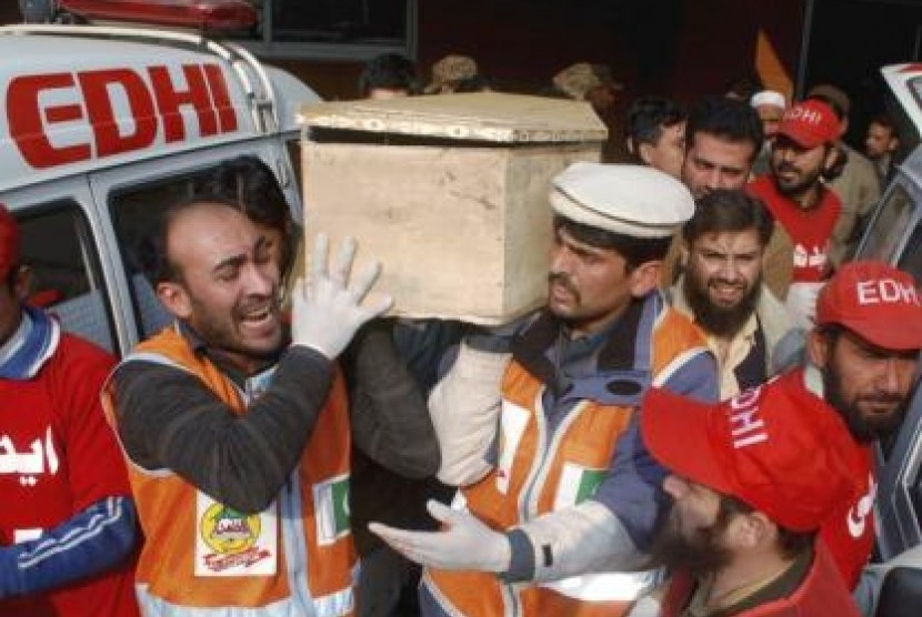 Rescue workers and family members carry the coffin of a student, who killed during an attack by Taliban gunmen on the Army Public School, in Peshawar, December 16, 2014.
