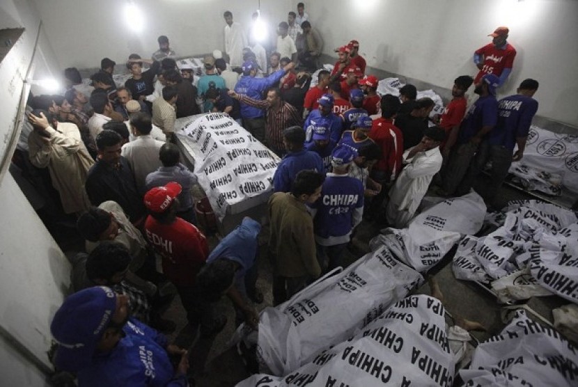 Rescue workers and residents gather at the morgue to identify relatives after a bomb blast in a residential area in Karachi March 3, 2013. 