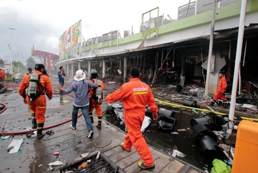 Rescue workers patrol a blast site outside a supermarket in Pattani, Thailand.