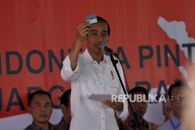 Presiden Republik Indonesia Joko Widodo menunjukan Kartu Indonesia Sehat saat memberikan sambutan pada kunjungan kerja di Taman Pendawa, Jalan Pendawa, Kota Bandung, Rabu (12/4). 