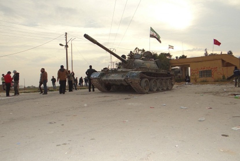 Residents and Free Syrian Army fighters pose near a tank after the fighters said they fought and defeated government troops from the town of Ras al-Ain, near the province of Hasaka, 600 km (375 miles) from Damascus, November 22, 2012.  