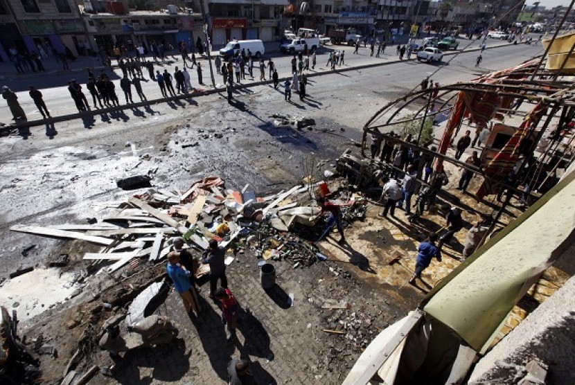 Residents gather at the site of a car bomb attack in the AL-Mashtal district in Baghdad March 19, 2013. 