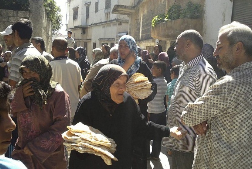 Residents gather outside a bakery to buy bread in Houla near Homs, June 9, 2012.   