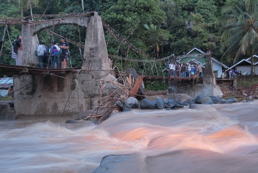 Residents watch the impact of flood from the bridge in Batu Busuk village, Padang, West Sumatra.  