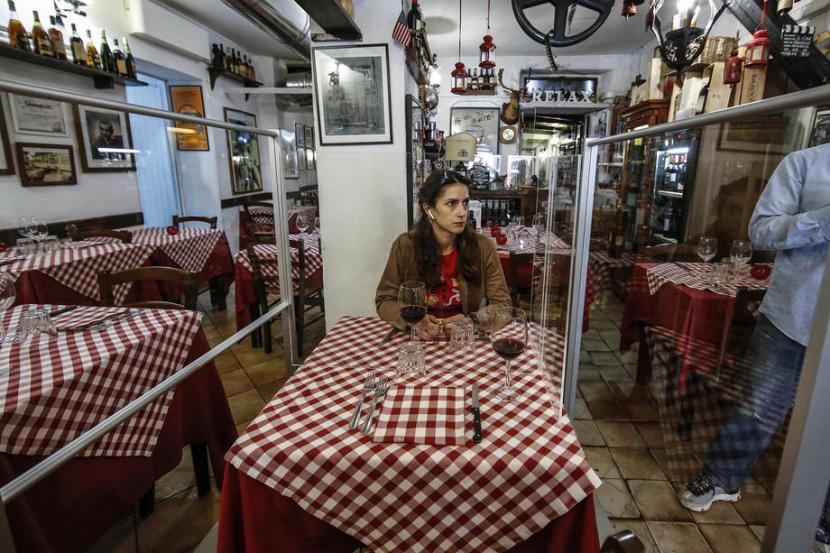 Restoran di Italia memasang plexiglass sebagai pemisah antarmeja. Penyesuaian itu dibuat usai Italia melonggarkan lockdown di tengah pandemi Covid-19.