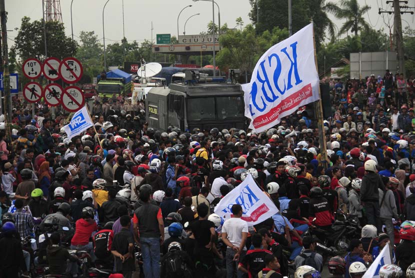 Ribuan buruh gabungan dari berbagai perusahaan berkumpul di depan gerbang Tol Jakarta-Merak KM-57, Ciujung, Serang, Banten, Selasa (3/12).  (Antara/Asep Fathulrahman)