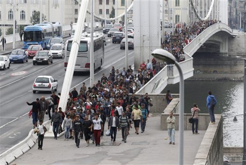 Ribuan imigran melintasi Jembatan Elizabeth di atas Sungai Danube dalam perjalanan menuju Austria dari stasiun kereta Keleti di Budapest, Hungaria, Sabtu (5/9).