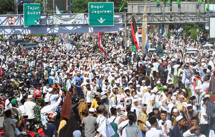 Ribuan jamaah menyambut kedatangan Imam Besar Habib Rizieq Shihab di Jalur Puncak, menuju Megamendung, Kabupaten Bogor, Jumat (13/11).