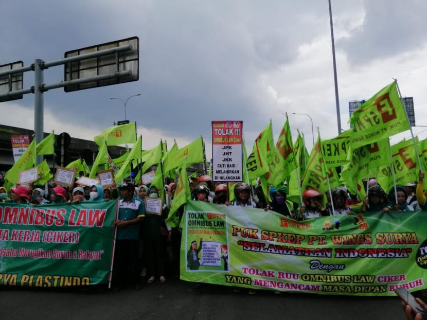 Ribuan orang yang merupakan gabungan dari buruh dan mahasiswa di Jawa Timur menggelar aksi unjuk rasa menolak RUU Cipta Kerja atau Omnibus Law di Bundaran Waru, Sidoarjo, Rabu (11/3).(Republika/Dadang Kurnia)