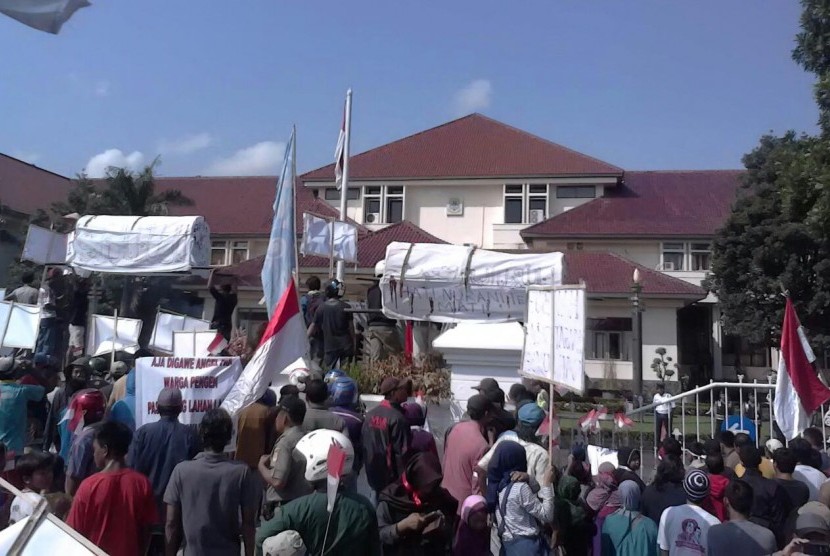 Ribuan Massa yang terdiri dari pedangan pasar Sumber, warga komunitas tukang ojek dan tukang becak, sopir angkot, karang taruna dan mahasiswa demo ke kantor Bupati Cirebon, Senin (28/3).
