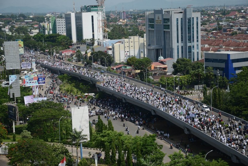 Ribuan orang berjalan saat berunjuk rasa di atas jalan jembatan layang menuju kantor Gubernur Sulsel di Makassar, Jumat (4/10). 