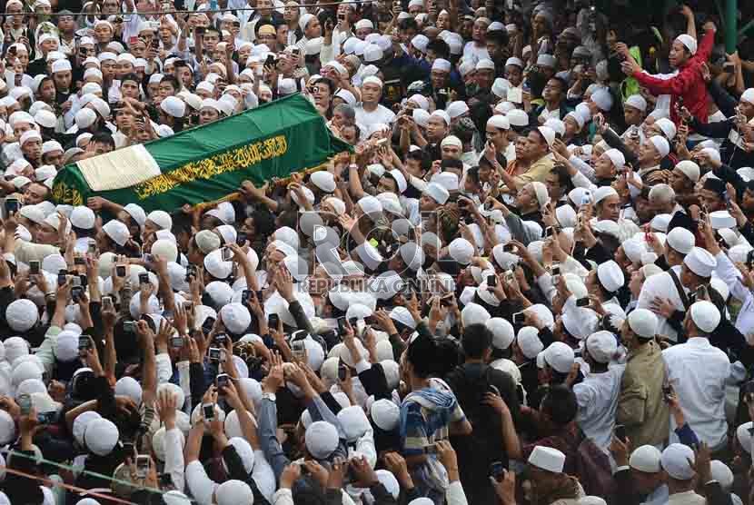  Ribuan pelayat mengangkat keranda jenazah Habib Munzir Al Musawwa saat hendak dimakamkan di kompleks pemakaman Habib Kuncung, kalibata, Jakarta Selatan, Senin (16/9).     (Republika/Agung Supriyanto)