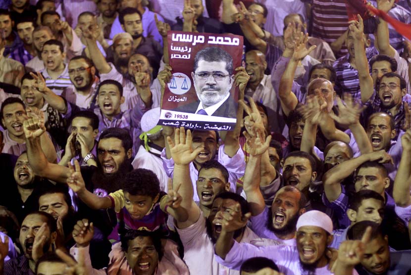 Ribuan pendukung Presiden Muhammad Mursi berunjuk rasa menolak kudeta militer di Giza, Kairo, Senin (15/7).     (AP/Amr Nabil)