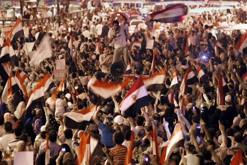 Pendukung Presiden Muhammad Mursi berunjuk rasa menolak kudeta militer di Giza, Kairo, Senin (15/7).  