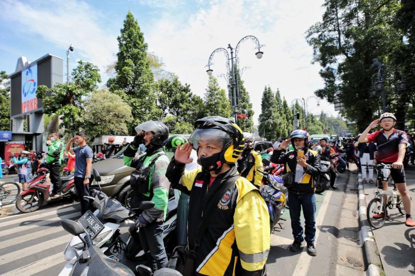 Ribuan pengendara roda dua dan empat di kawasan lampu merah simpang lima Jalan Asia Afrika, Kota Bandung tiba-tiba mematikan mesin kendaraan sejenak. Mereka melakukan aksi 3 menit untuk Indonesia di HUT Kemerdekaan ke 77 dengan mengheningkan cipta dan menyanyikan lagu Indonesia Raya, Rabu (17/8/2022). 