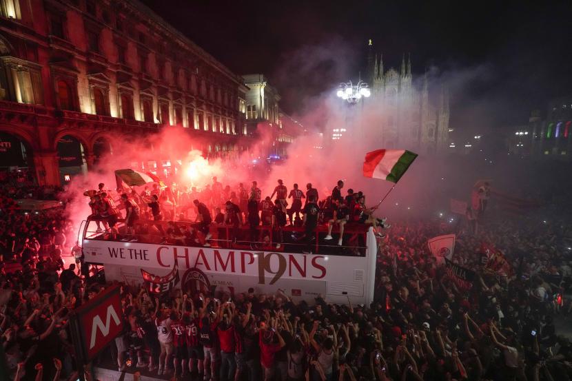  Ribuan penggemar bersorak saat bus membawa para pemain tim sepak bola AC Milan yang berjaya merayakan gelar liga teratas Serie A Italia ke-19 mereka, di depan katedral Gotik Milan, di Milan, Italia, Senin, 23 Mei 2022.