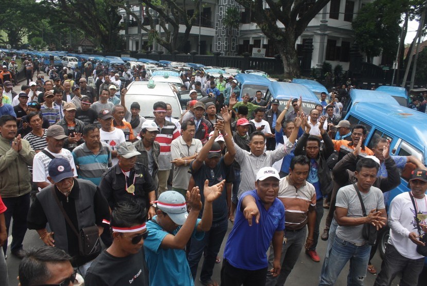 Ribuan supir angkutan melakukan mogok massal dan berunjuk rasa menolak keberadaan transportasi berbasis aplikasi online di depan Balaikota Malang, Jawa Timur, Selasa (26/9). 