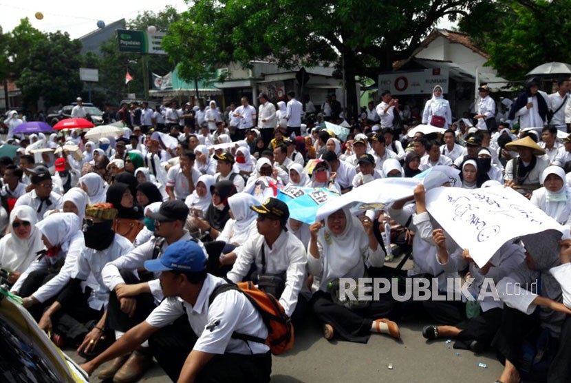 Ribuan tenaga honorer yang tergabung dalam Forum Honorer Kabupaten Indramayu menggelar unjuk rasa di depan gedung DPRD Indramayu, Senin (20/11). 