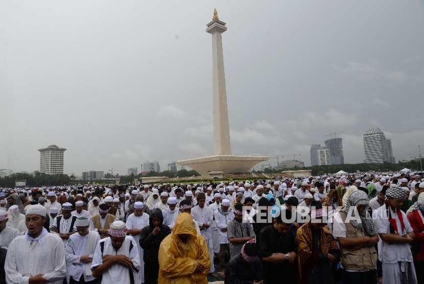 Jutaan umat islam tetap melaksanakan sholat jumat meskipun hujan di halaman Monas dalam rangka Aksi Bela Islam 3, Jakarta, Jumat (2/12). 