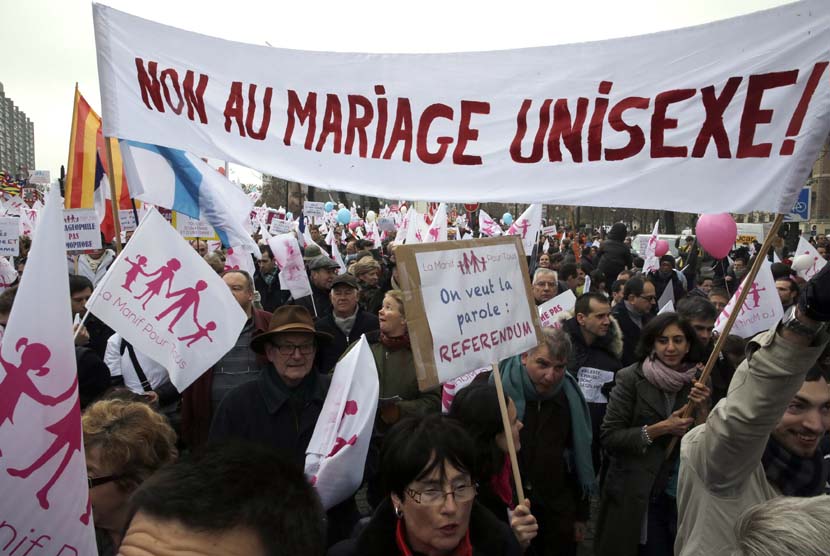   Ribuan warga berunjuk rasa di Champ de Mars dekat Menara Eiffel memprotes rencana legalisasi pernikahan sesama jenis di Paris, Ahad (13/1).  (Reuters/Philippe Wojazer)
