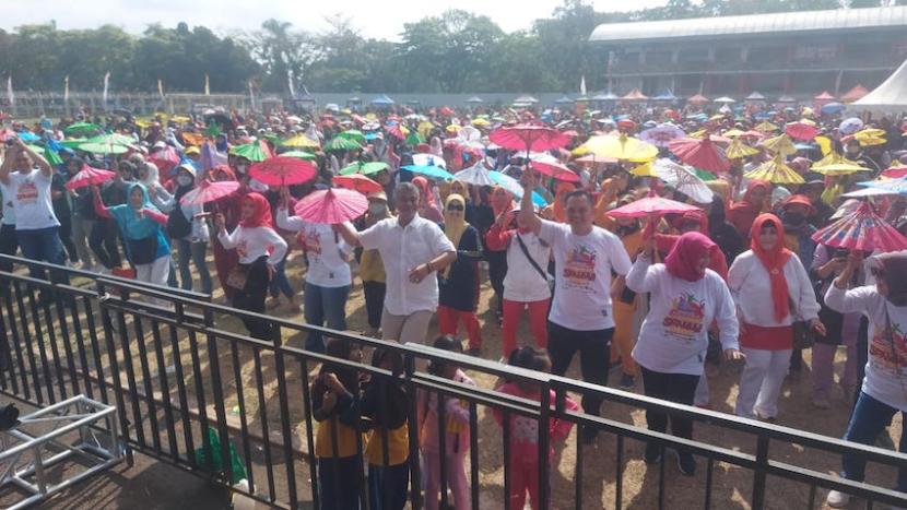 Ribuan warga mengikuti kegiatan senam massal sambil membawa payung geulis di Stadion Wiradadaha, Kompleks Olahraga Dadaha, Kota Tasikmalaya, Jawa Barat, Ahad (10/9/2023). 