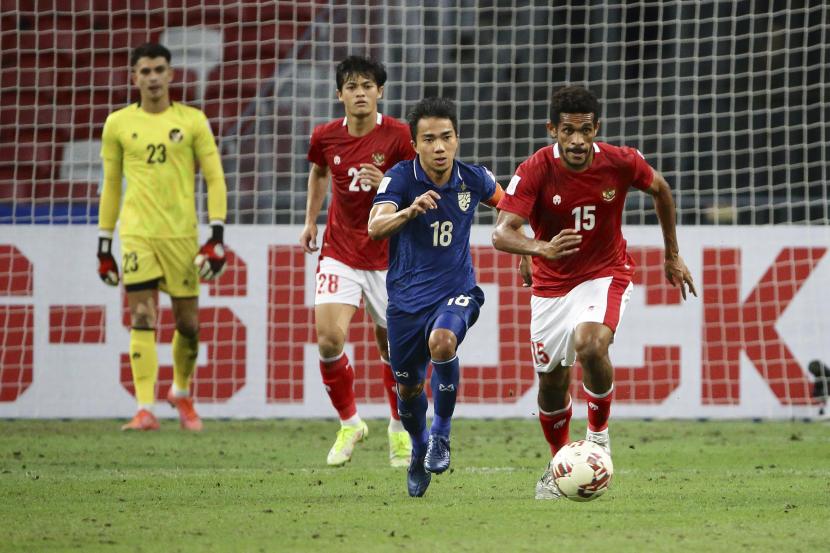 Ricky Richardo Kambuaya dari Indonesia, kanan, dan Chanathip Songkrasin dari Thailand bersaing memperebutkan bola pada pertandingan leg kedua final AFF Suzuki Cup 2020 antara Thailand dan Indonesia di Singapura, Sabtu, 1 Januari 2022.