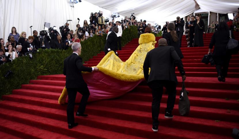 Rihanna tampak dari belakang saat sedang menapaki anak tangga Metropolitan Museum of Art, lokasi Met Gala 2015, dengan gaun kuning ikoniknya.