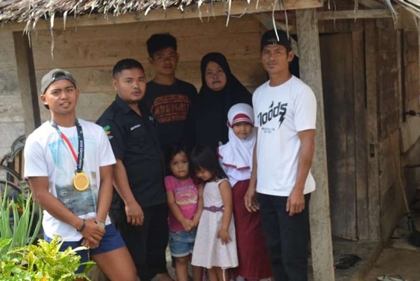 Rio Rizky Darmawan (kiri) bersama keluarga dan Pendamping PKH Kecamatan Kulawi Selatan Sigi Sulawesi Tengah Aziz Wilkerson di rumahnya di Kulawi Selatan Sigi Sulawesi Tengah.