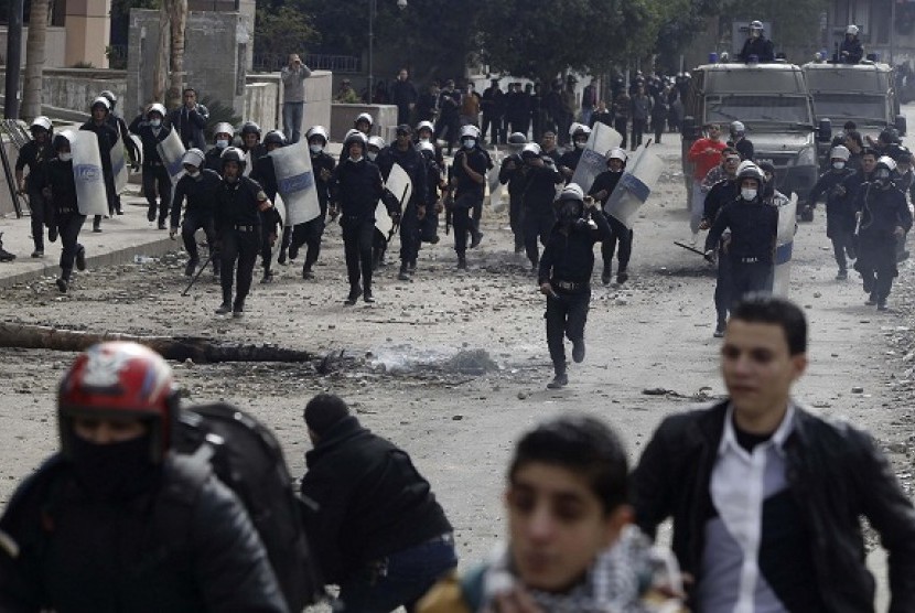Riot police run towards protesters opposing Egyptian President Mohamed Mursi during clashes, along Qasr Al Nil bridge, which leads to Tahrir Square in Cairo January 28, 2013. 