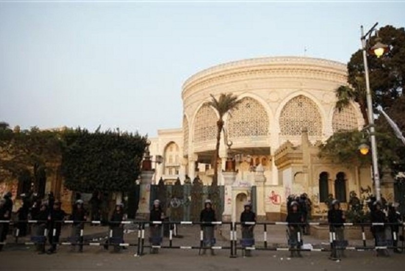 Riot police stand guard in front of the presidential palace in Cairo December 16, 2012.  