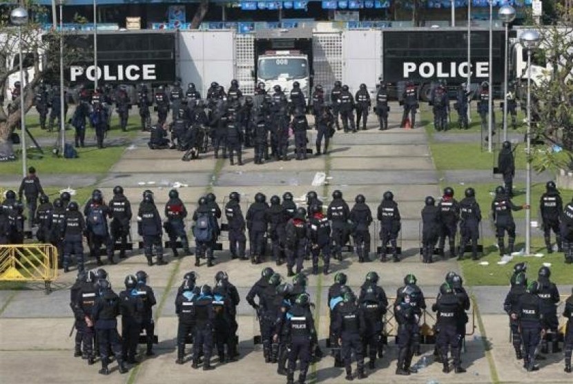 Riot policemen stand guard during clash with anti-government protesters at the Thai-Japan youth stadium in central Bangkok December 26, 2013.