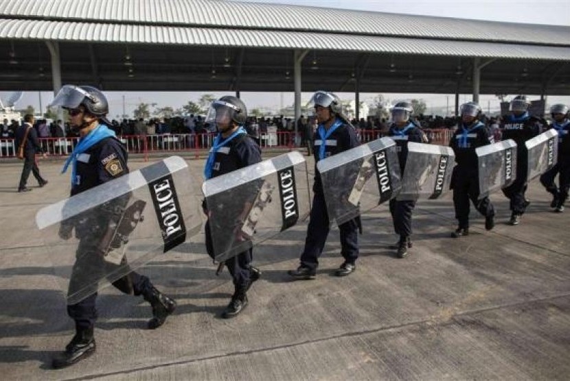 Riot policemen walk around during a registration of election candidates at a bus terminal centre near the Government complex in Bangkok December 28, 2013.