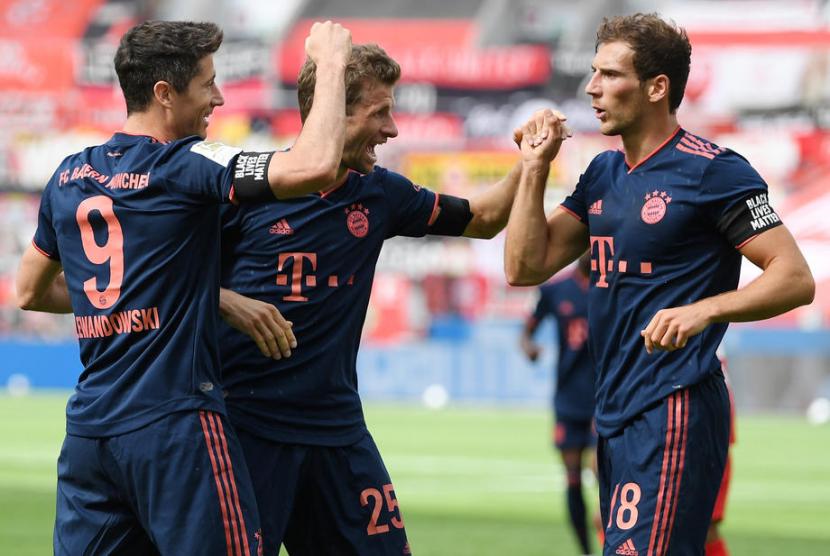 Robert Lewandowski (Kiri ) merayakan golnya bersama Thomas Mueller (tengah) and Leon Goretzka (Kanan) saat Muenchen bertemu Leverkusen, Ahad Dini Hari WIB. Muenchen menang 4-2 atas Leverkusen.