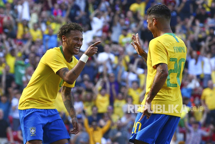 Roberto Firmino  melakukan selebrasi dengan rekan setimnya Neymar setelah mencetak gol kedua timnya pada laga persahabatan antara Brasil dan Kroasia di Stadion Anfield di Liverpool,  Inggris, Ahad (3/6).