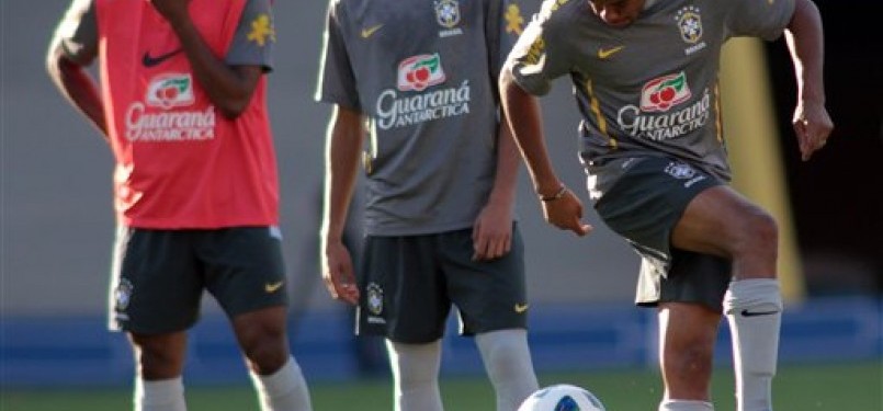 Robinho (kiri) memainkan bola disaksikan rekan-rekannya,Neymar dan Elias, pada saat latiha di Goiania, Brazil.