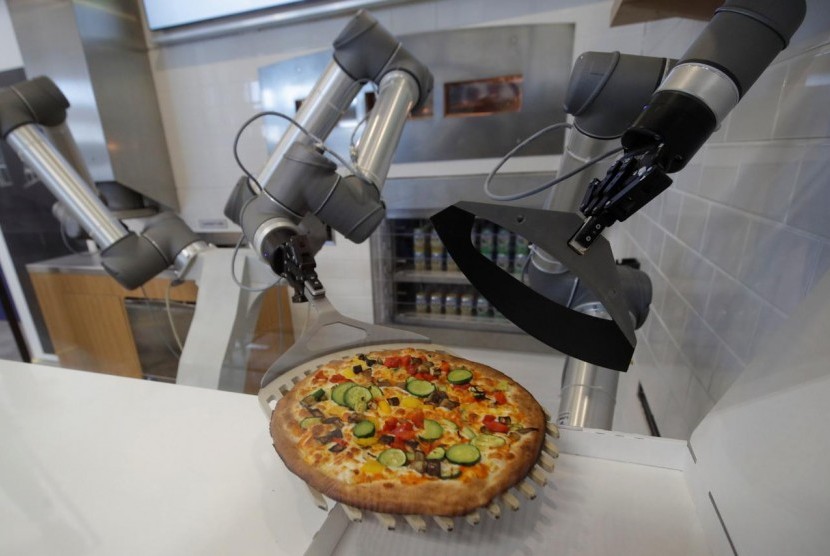 Robot pembuat pizza memamerkan kemampuannya di Montevrain, dekat Paris, Prancis, 26 Juni 2018.