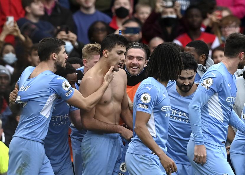 Rodri (tengah) dari Manchester City merayakan dengan rekan satu timnya setelah mencetak keunggulan 2-1 selama pertandingan Liga Premier Inggris antara Arsenal London dan Manchester City di London, Inggris, Sabtu (1/1/2022)..
