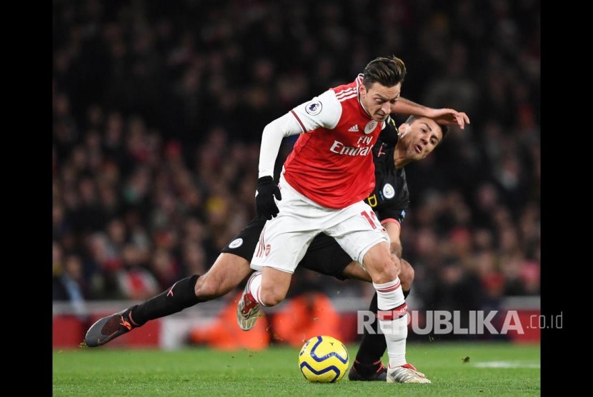 Rodrigo menempel ketat Mesut Ozil pada laga antara Arsenal melawan Manchester City di Etihad Stadium, London, Ahad (15/12).