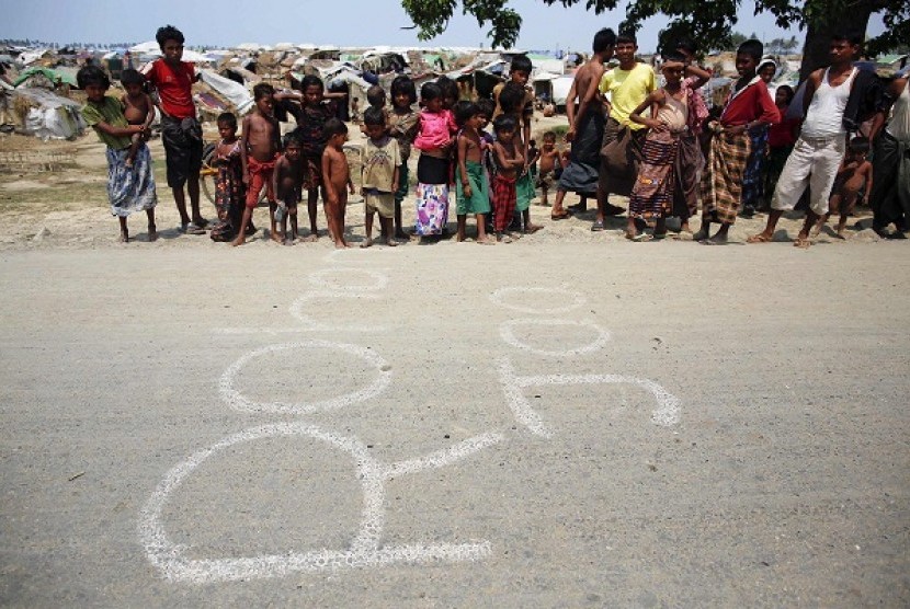 Rohingya Muslims stand beside the word 
