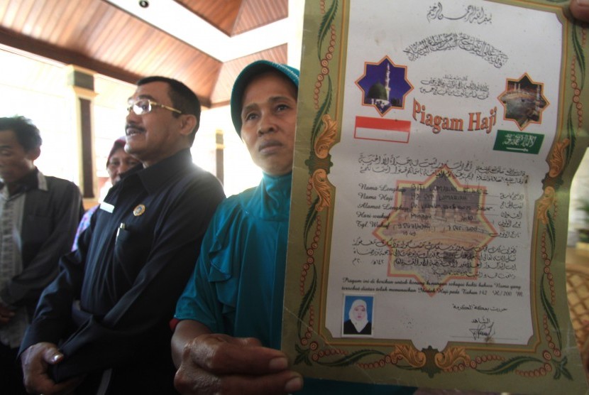 Rokmi (kanan) menunjukan foto Siti Komariah salah satu Tenaga Kerja Wanita (TKW) yang terlibat kasus Pembunuhan di Arab Saudi saat mendatangi Pendopo Indramayu, Jawa Barat, Rabu (20/5).