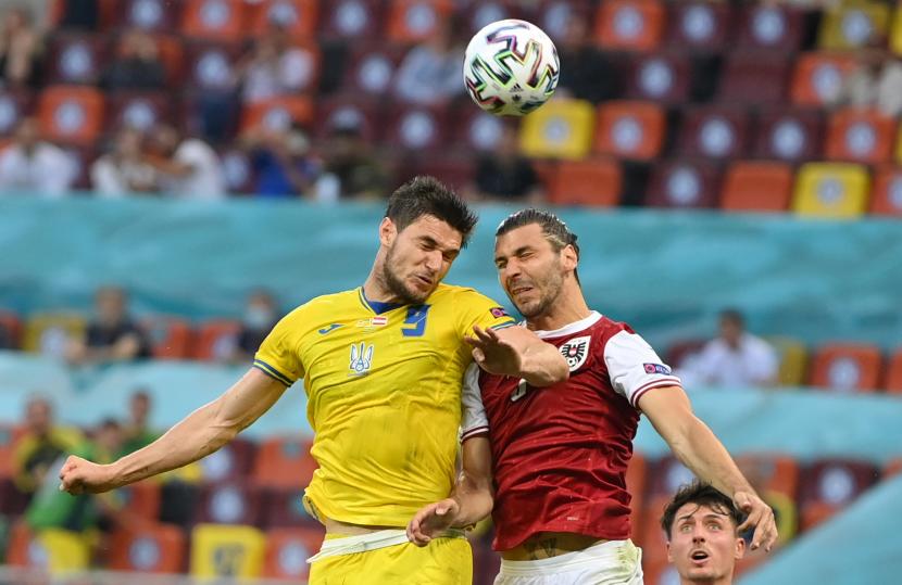  Roman Yaremchuk (kiri) dari Ukraina beraksi melawan Aleksandar Dragovic dari Austria selama pertandingan sepak bola babak penyisihan grup C UEFA EURO 2020 antara Ukraina dan Austria di Bucharest, Rumania, 21 Juni 2021. 