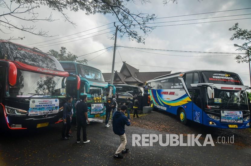 Rombongan bus pariwisata bersiap menggelar konvoi di Kawasan Kantor Tourism Information Center (TIC) saat pelepasan konvoi bus di Kabupaten Ciamis, Jawa Barat, Sabtu (11/7/2020). Sebanyak 24 bus pariwisata yang tergabung dalam Ikatan Perusahaan Otobus Priangan timur (IPOTI) melakukan konvoi dari Tasikmalaya menuju Pangandaran untuk mempromosikan pariwisata di Jabar setelah memasuki era normal baru dengan tetap menerapkan protokol kesehatan.