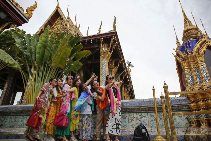 Rombongan turis berpose dengan latar Grand Palace di Bangkok, Thailand.