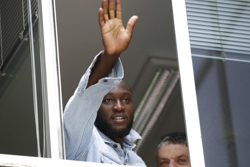 Romelu Lukaku melambaikan tangan ke pendukung Inter Milan dari jendela markas Komite Olimpiade Italia, di Milan, Italia, Kamis, (8/8/2019).