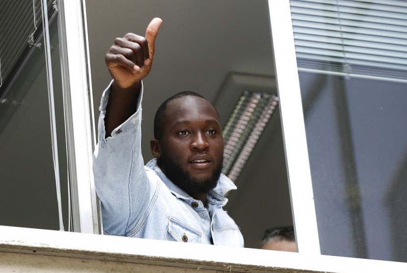 Romelu Lukaku mengacungan jempol ketika ia memberi hormat kepada pendukung Inter Milan dari jendela markas Komite Olimpiade Italia, di Milan, Italia, Kamis (8/8/2019).