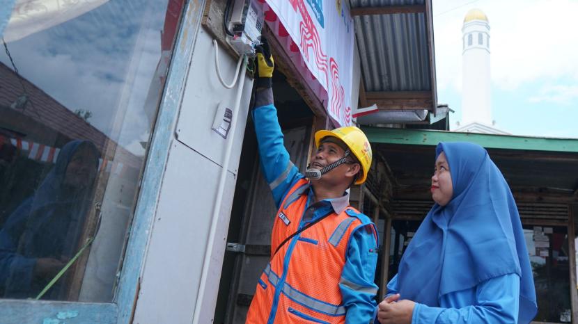 Rona bahagia terpancar dari wajah Jumaidah (kanan) penerima manfaat program Light Up The Dream di Kecamatan Gandus, Palembang  oleh petugas PLN.