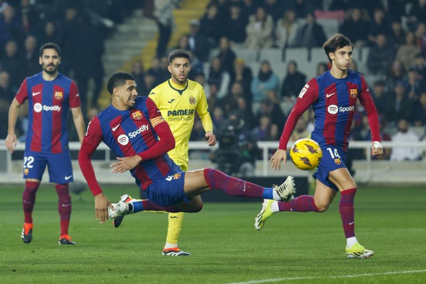 Ronald Araujo dari Barcelona, tengah, menendang bola saat pertandingan sepak bola La Liga Spanyol antara Barcelona dan Villarreal di stadion Olimpic Lluis Companys di Barcelona, Spanyol, Ahad (28/1/2024) dini hari WIB.. 